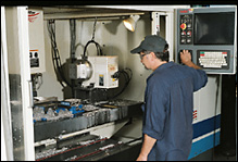 picture of a machine shop worker operating a CNC machine
